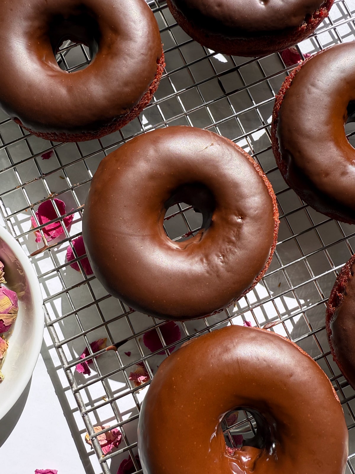 Top view of glazed donuts on wire cooling rack.