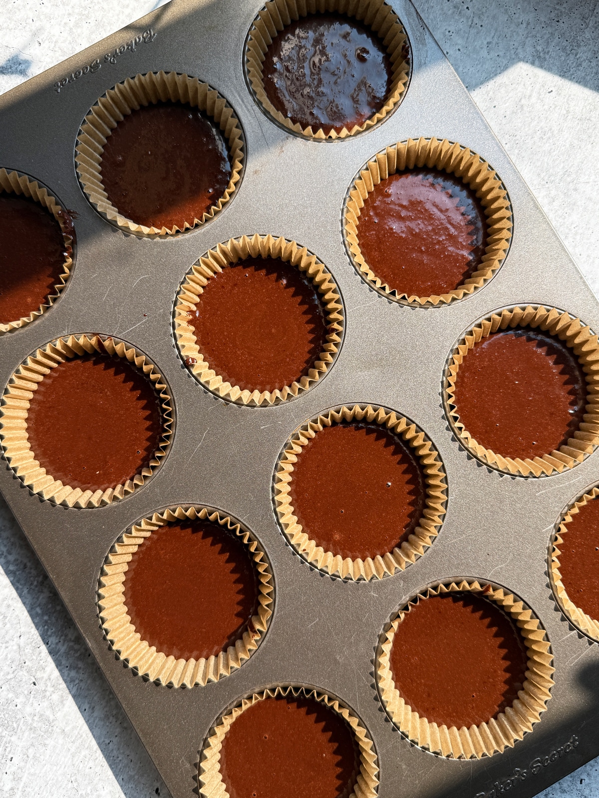 Cupcake batter in lined muffin tin.