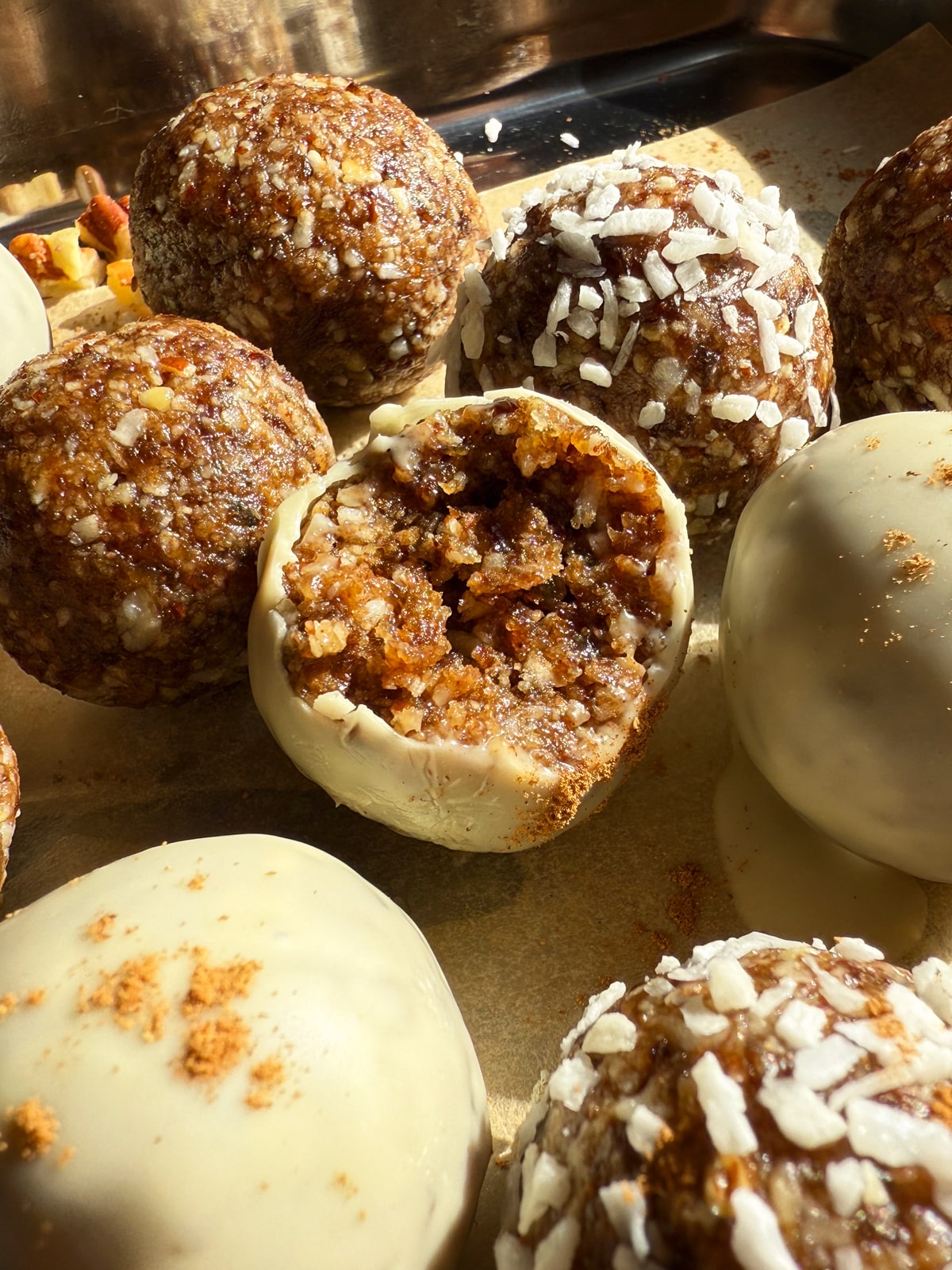 Bite of a cinnamon roll energy bite that was dipped in white chocolate.