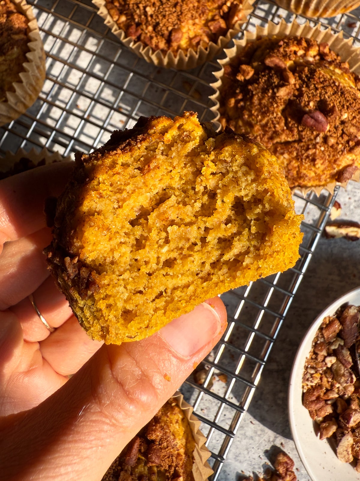 Holding a muffin with a bite out of it to show the moist texture.
