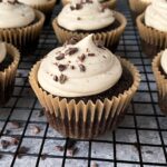 Frosted and decorated chocolate cupcakes on wire cooling rack.