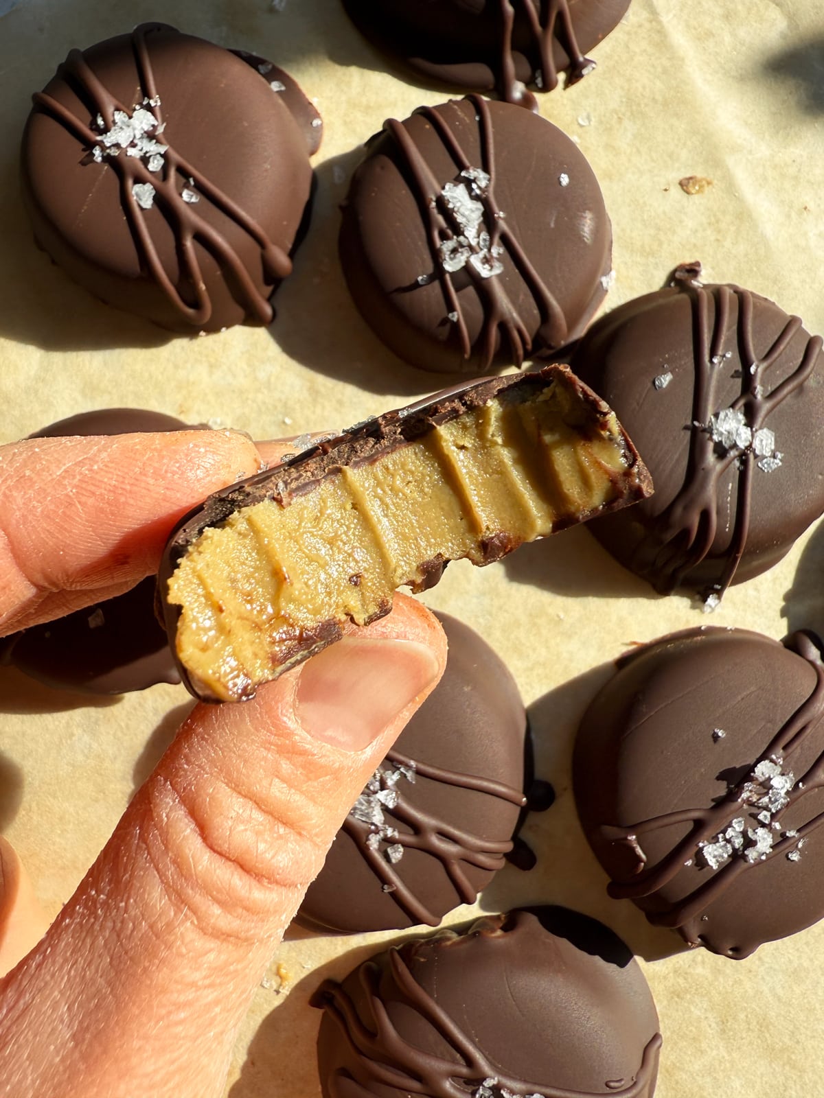 Holding a sunbutter cup with a bite out of it.