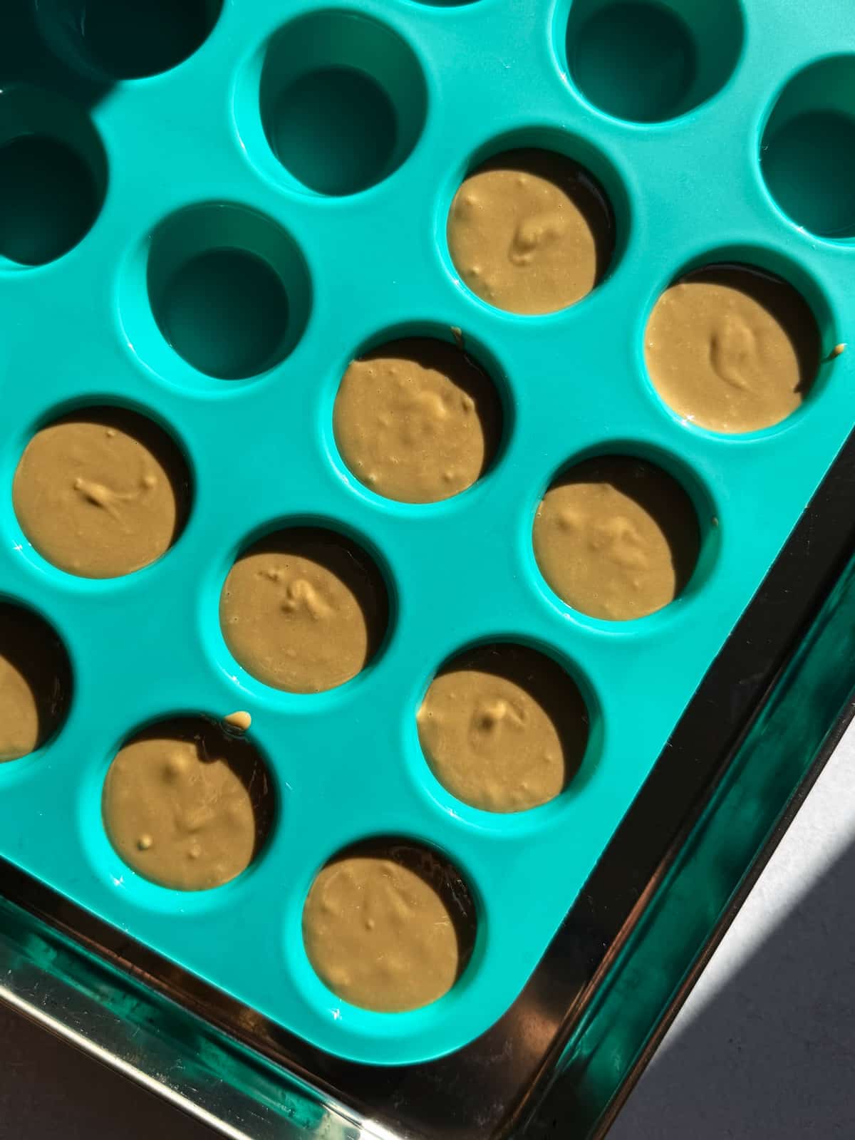 Filling in mini silicone muffin pan.