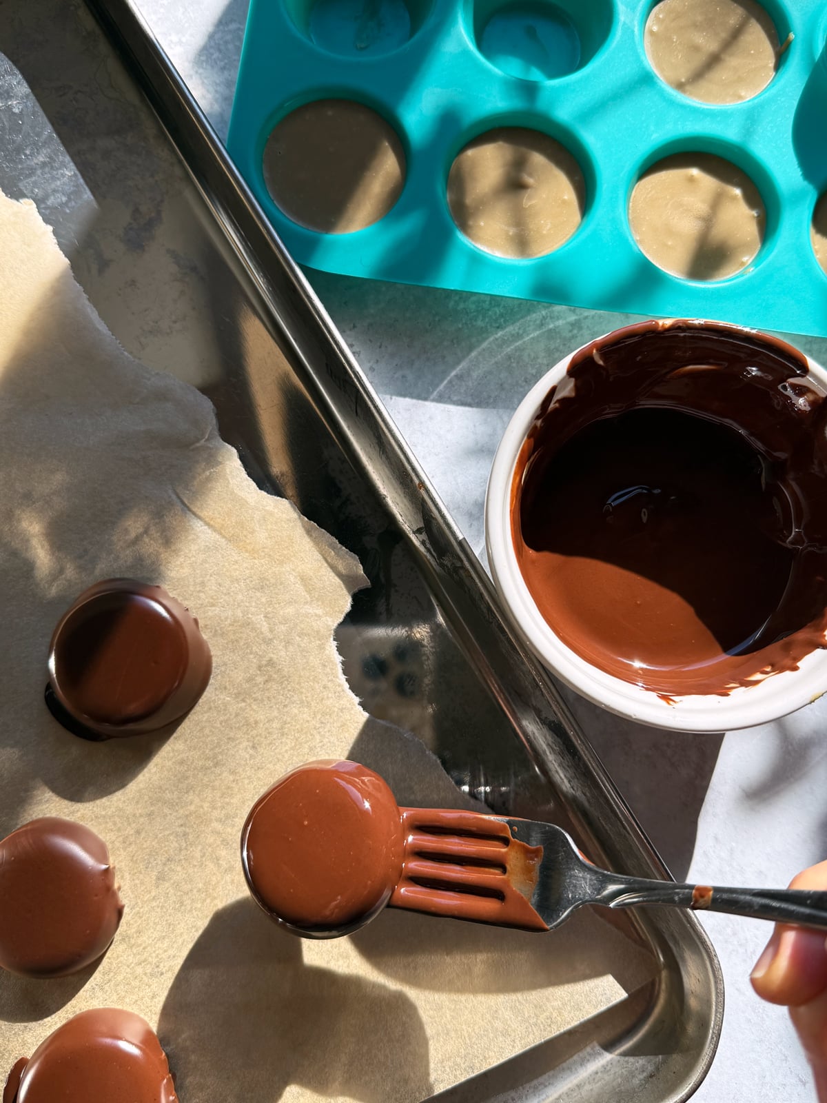 Dipping the frozen fillings in to dark chocolate.