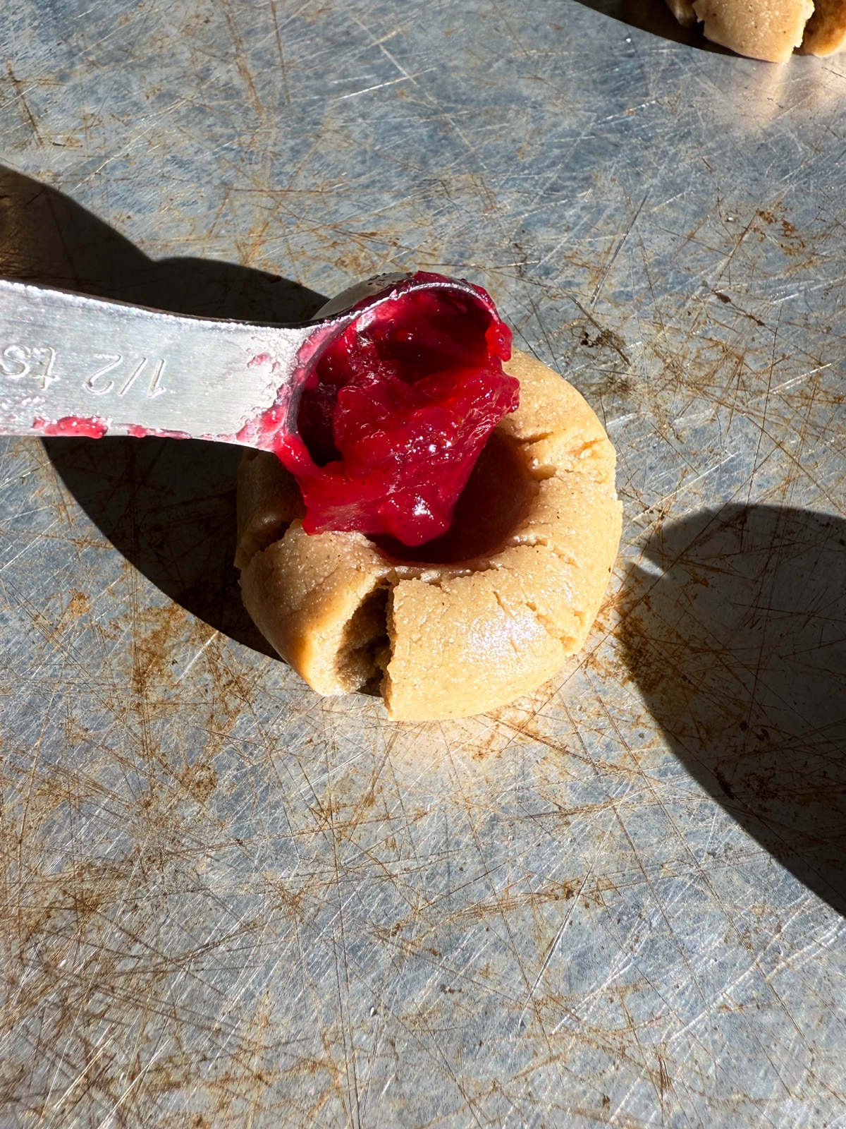 Adding the cranberry sauce to the unbaked cookies.