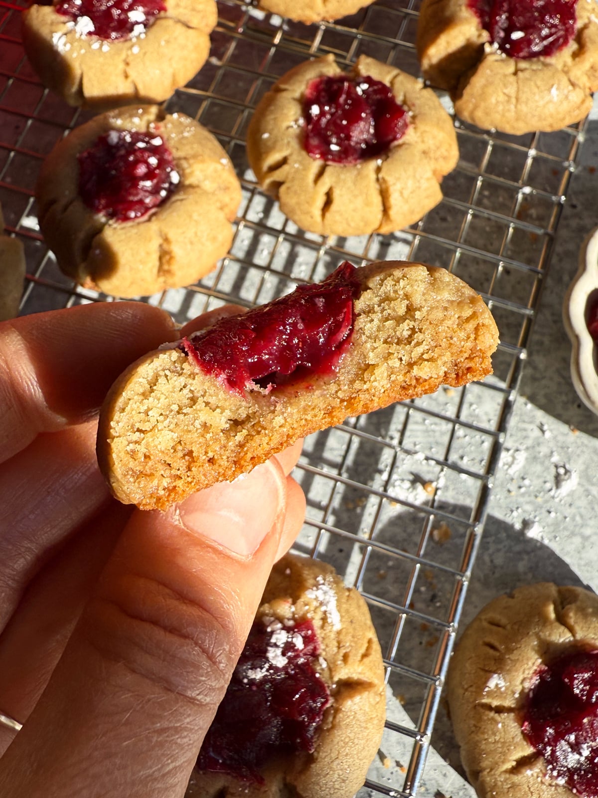 Holding a cookie with a bite out of it.