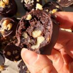 Holding a truffle with a bite out of it to show the inside texture.