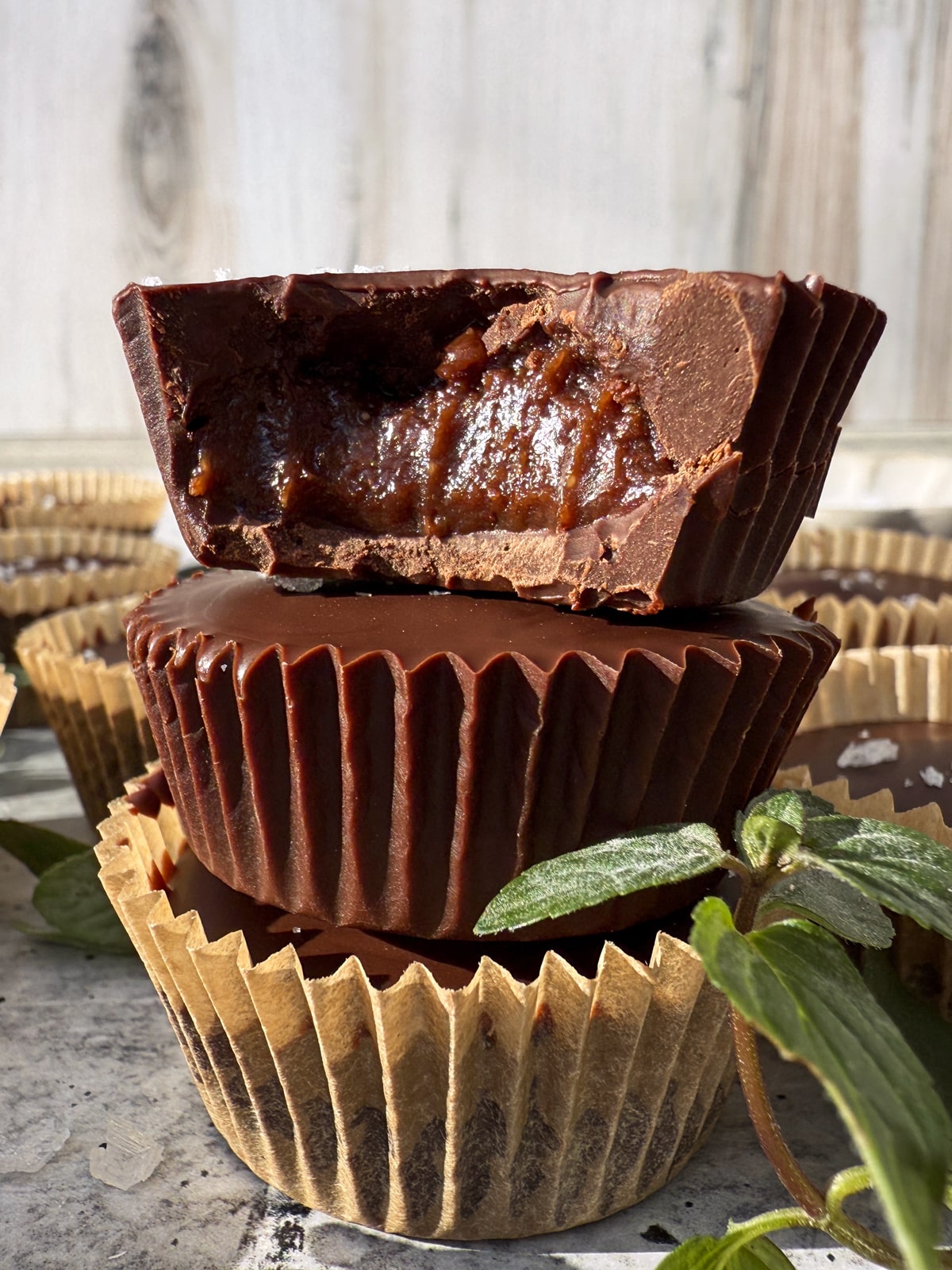 Close up of a stack of three mint chocolate almond butter cups.