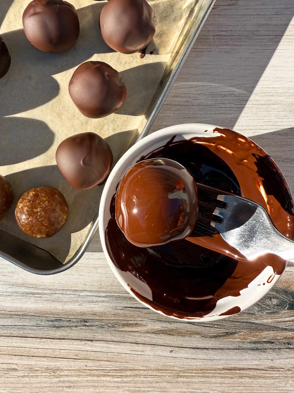 Dipping the balls in dark chocolate.