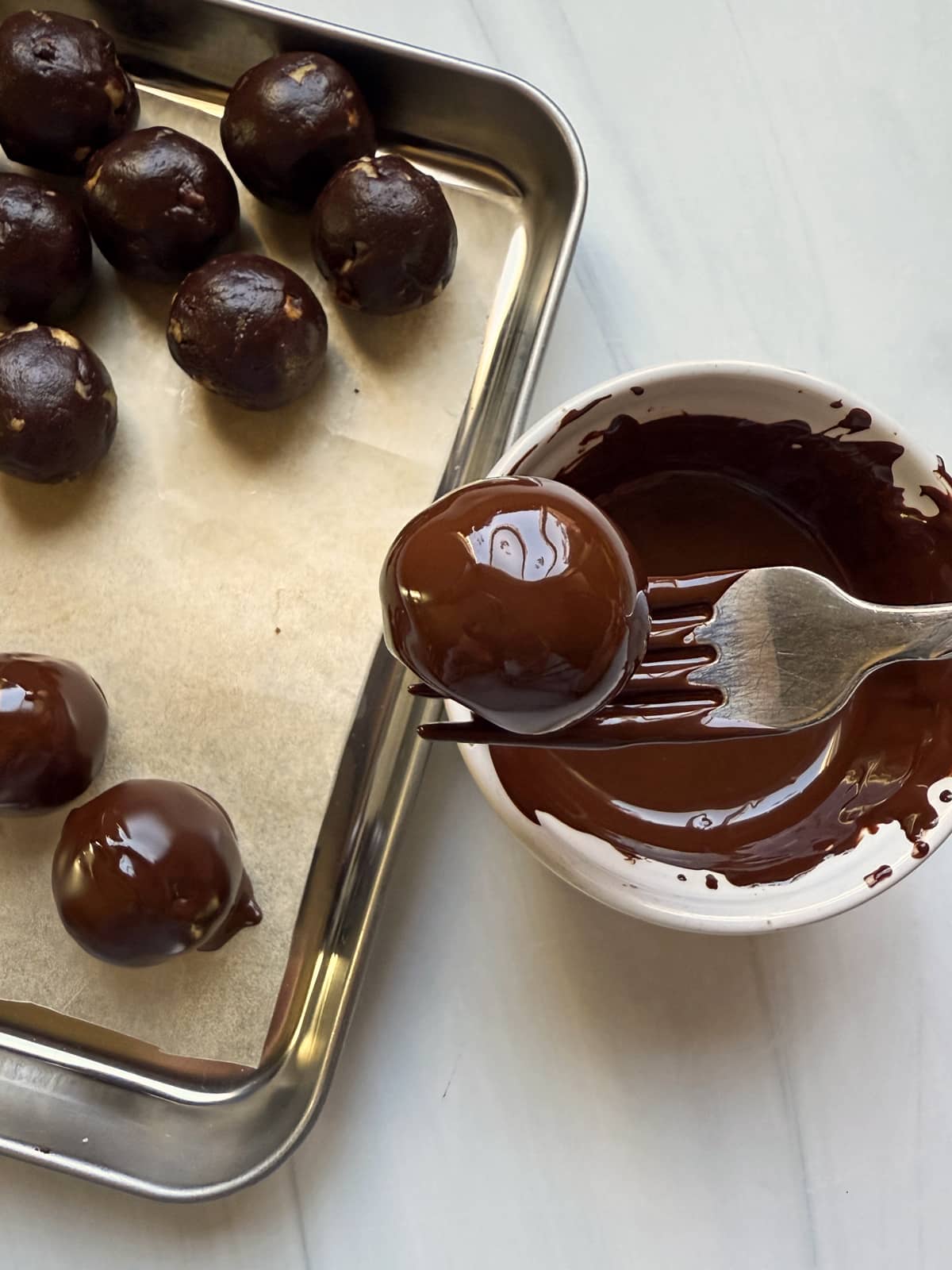 Dipping the filling in melted chocolate.