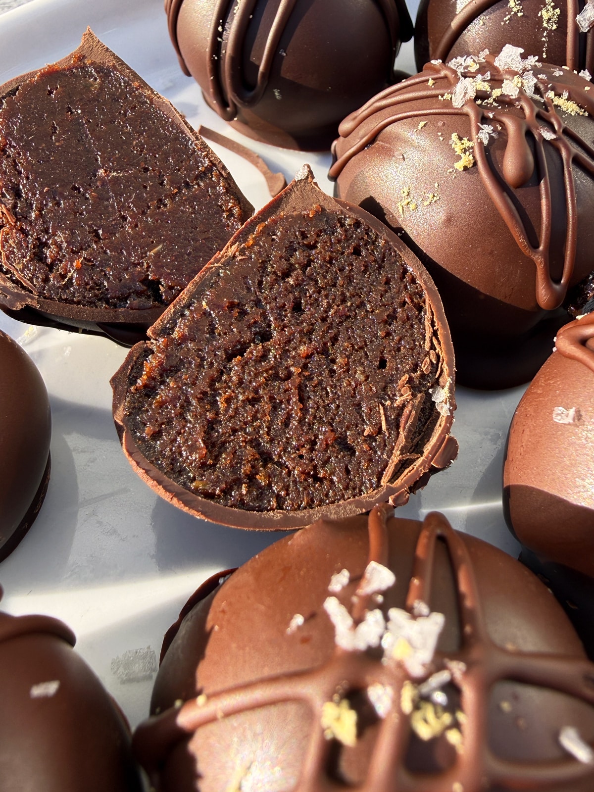 Close up of a chocolate gingerbread truffle that's been cut in half.