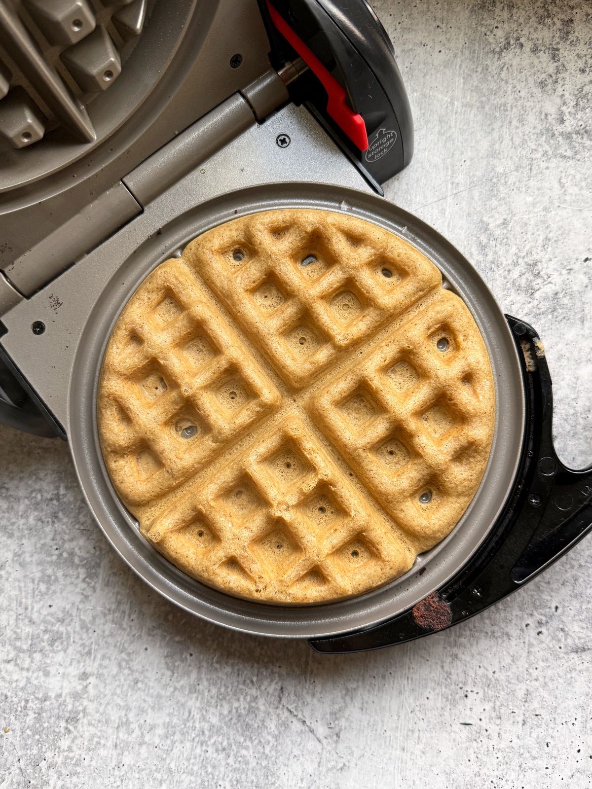 Waffle cooking on Belgium waffle maker.