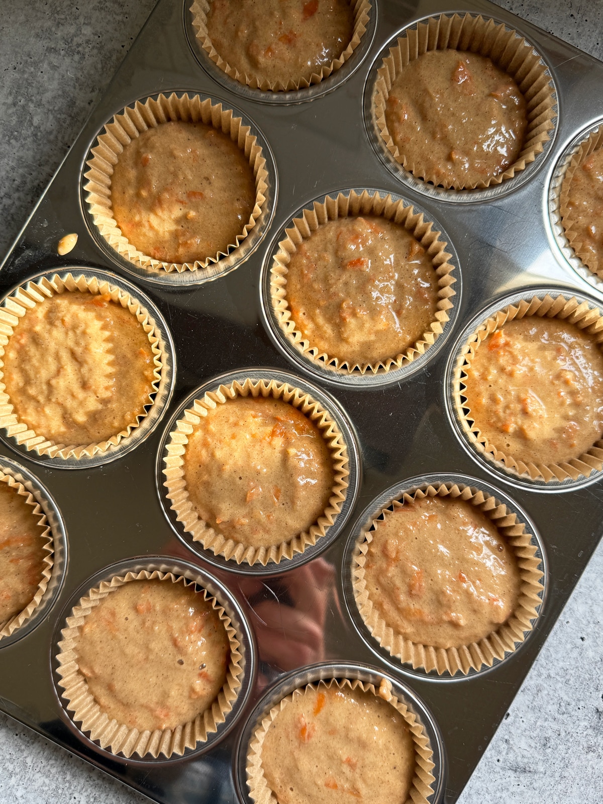 Muffin batter in lined muffin pan.