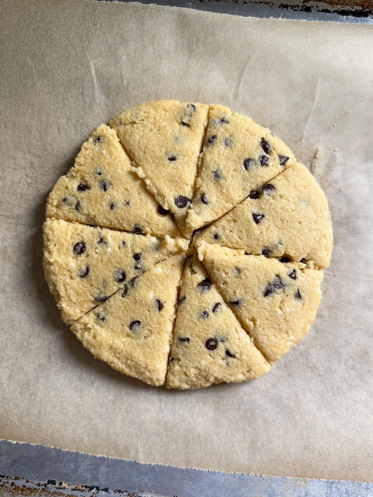 Shaped and cut scones on lined baking sheet.