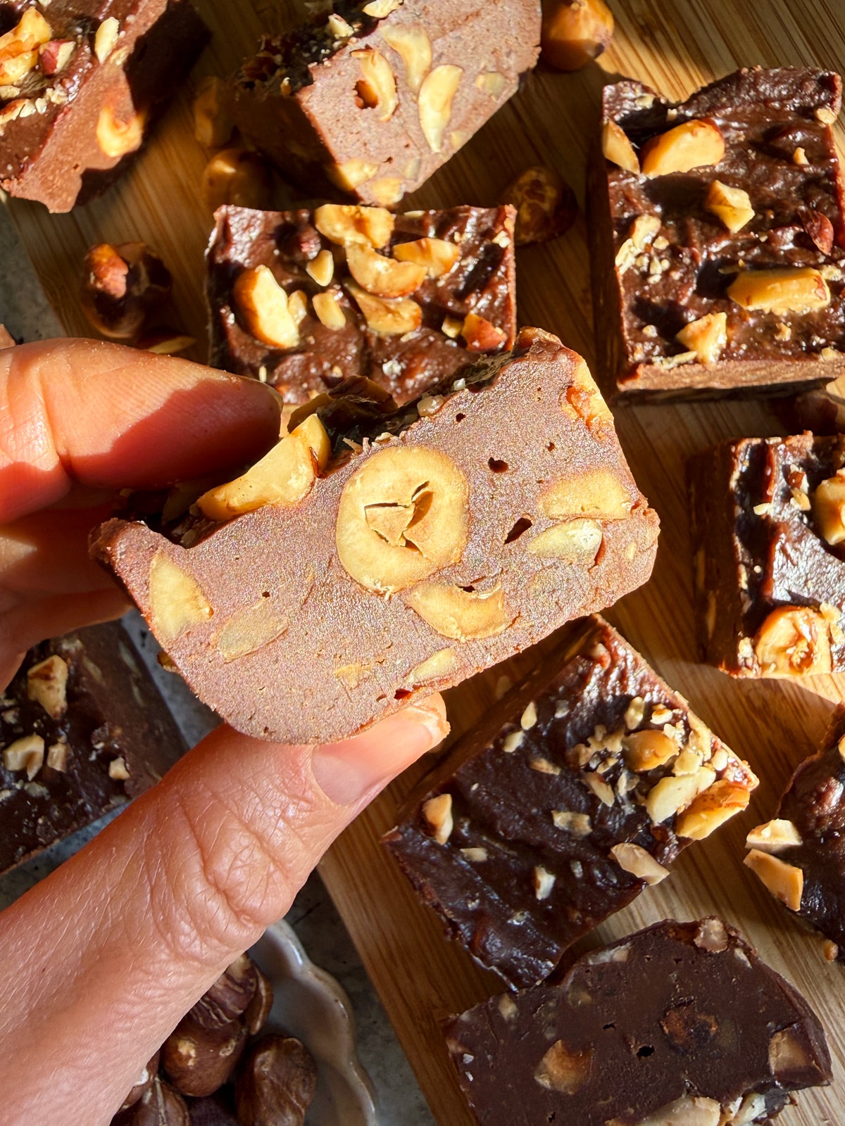 Holding a piece of fudge to show a close up of the texture.