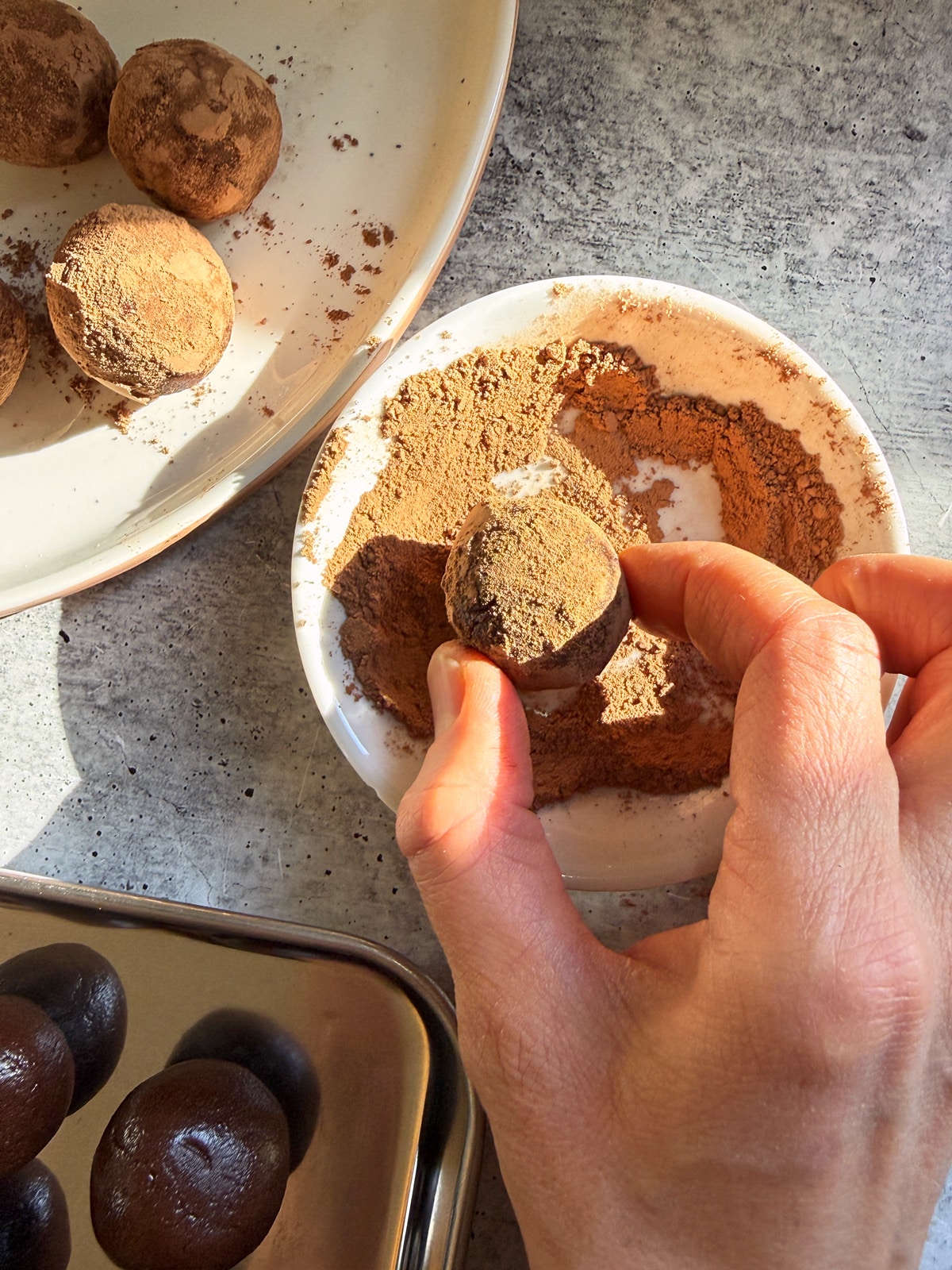 Rolling some of the protein balls in cacao powder.