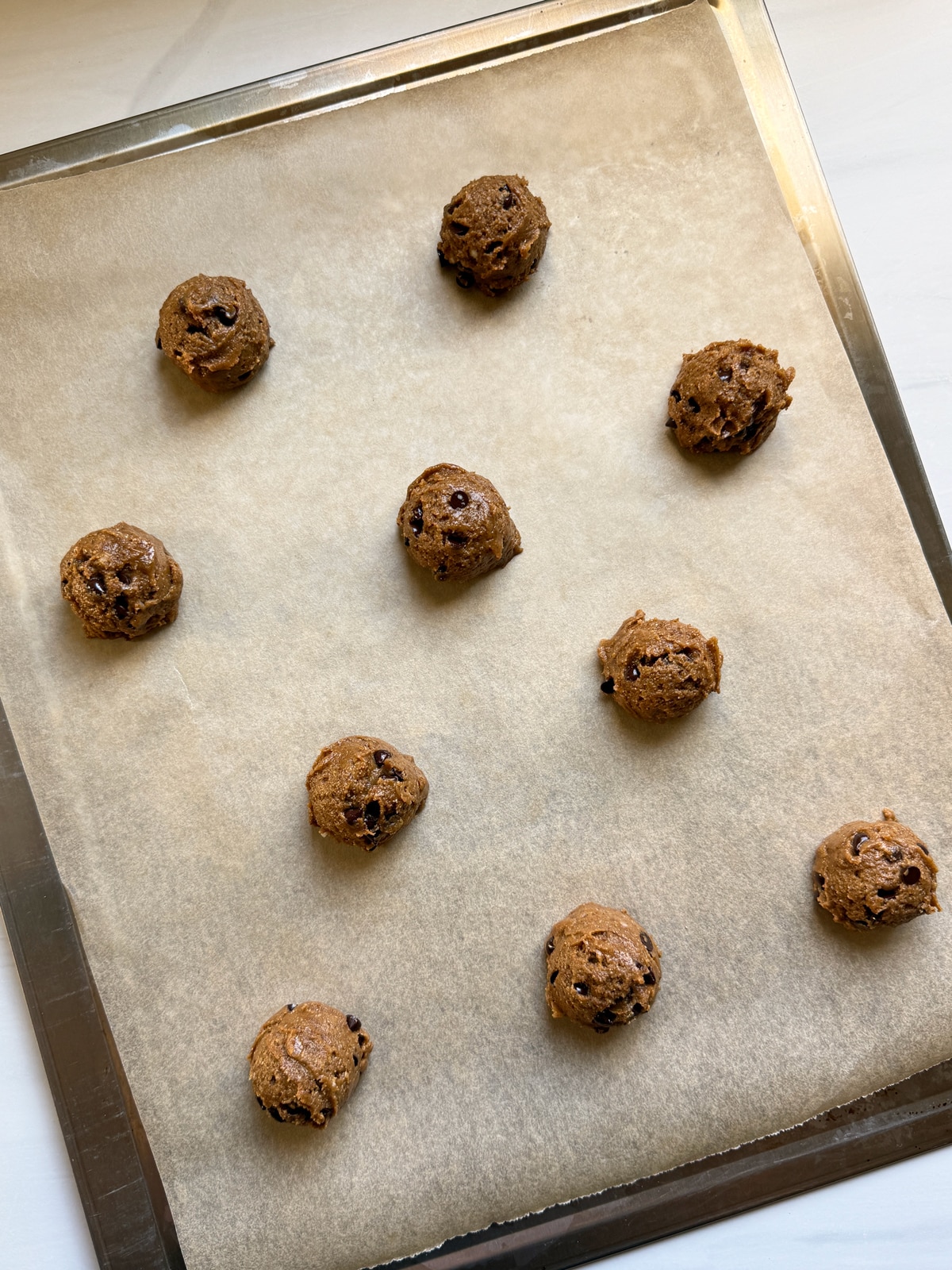 Cookie dough on lined baking sheet, ready to bake.