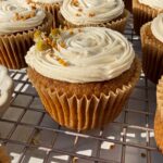 Cupcakes decorated with paleo vanilla frosting, bee pollen and edible flowers.