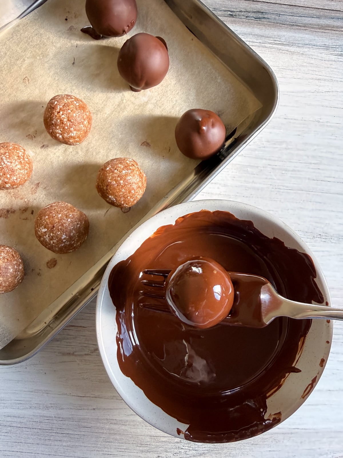 Dipping the balls in dark chocolate.