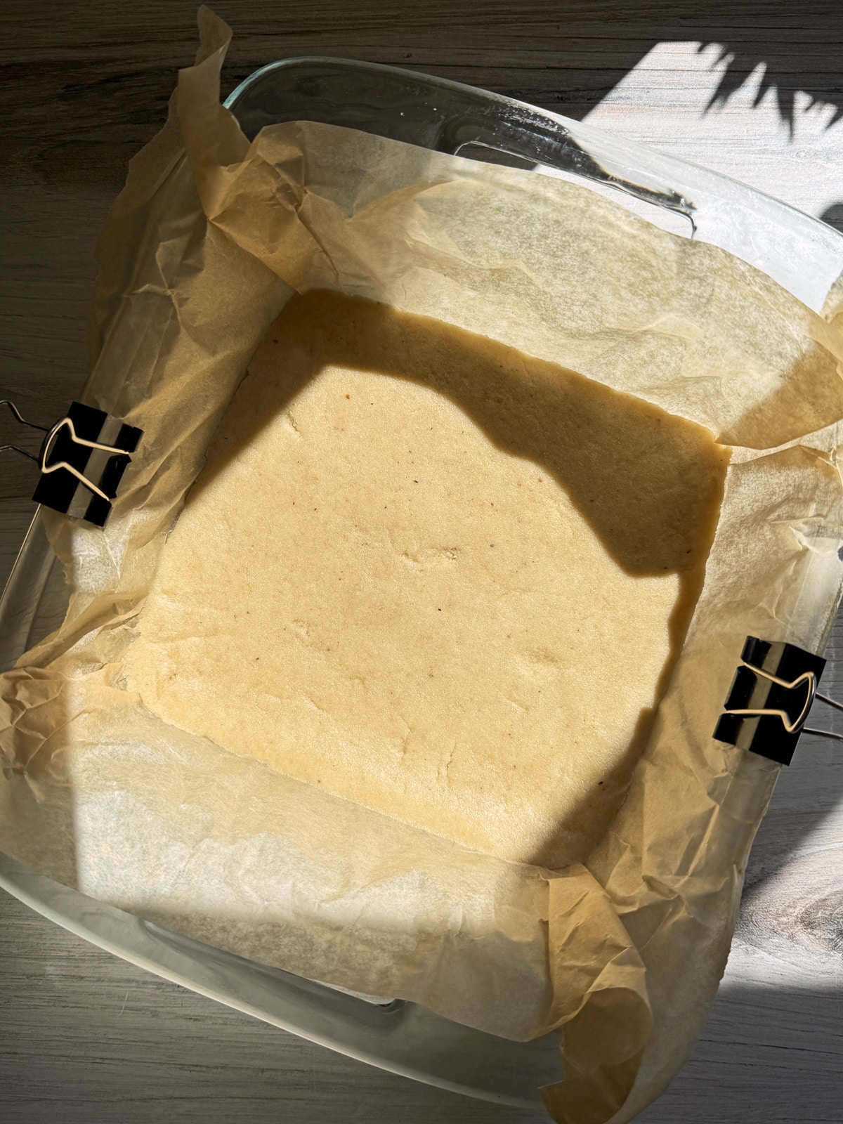 Crust dough pressed into a lined 8x8 inch baking pan.
