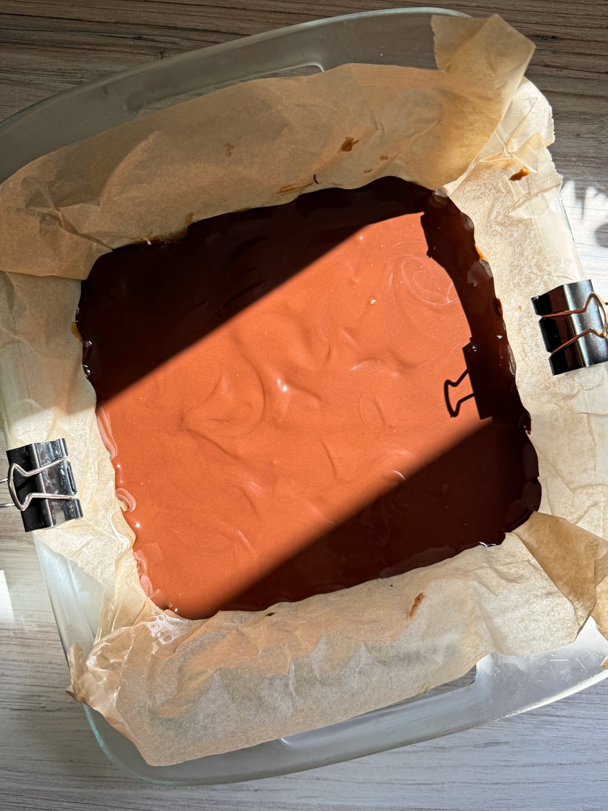 Chocolate topping spread over date caramel layer.