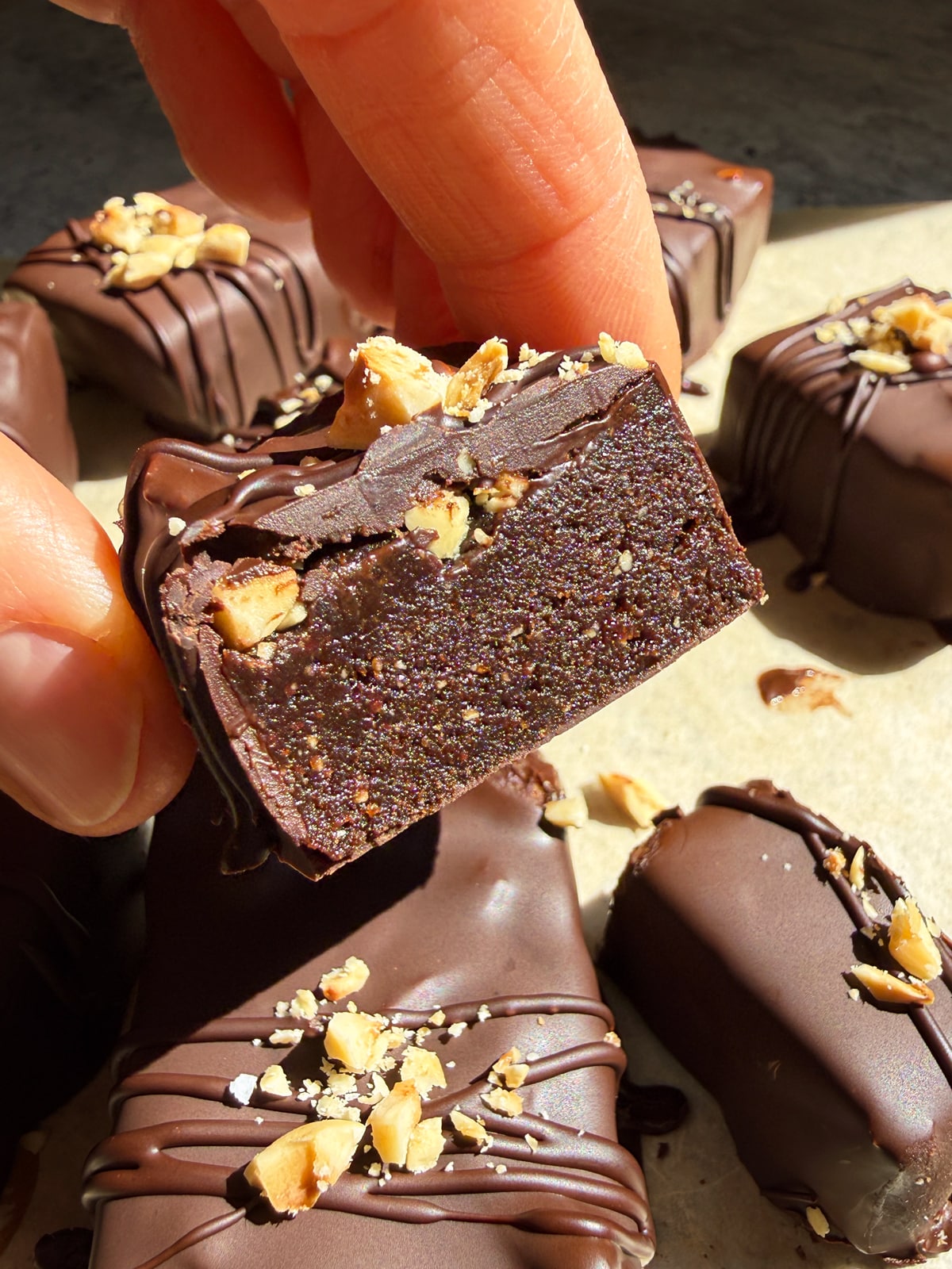Holding a hazelnut bar that's been cut in half to show the inside texture.