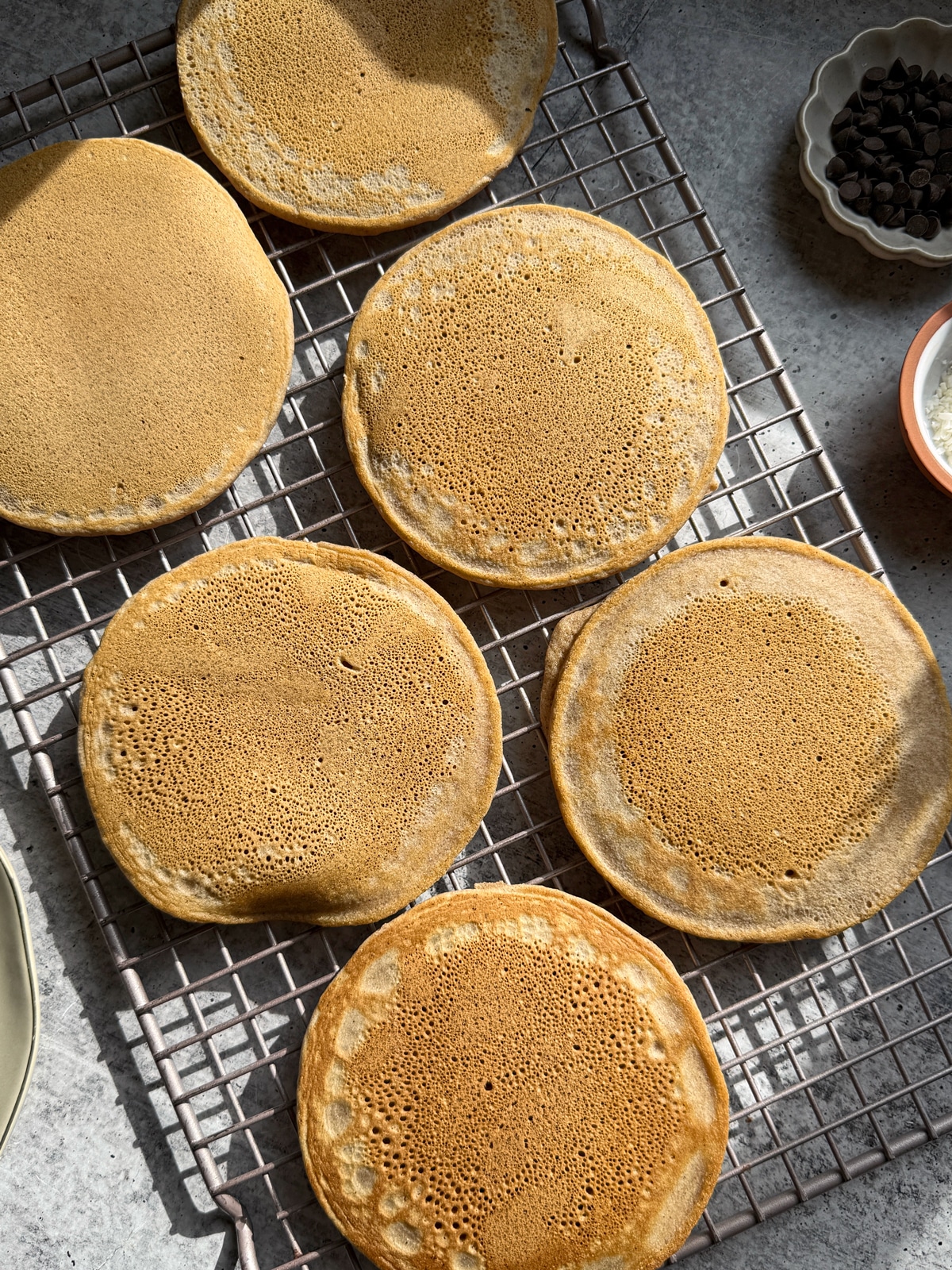 Top down view of pancakes on wire cooling rack.