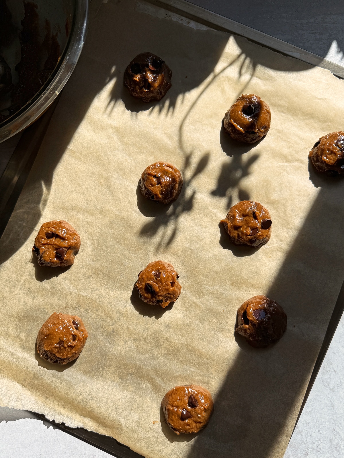 Cookie dough scooped onto a lined baking sheet.