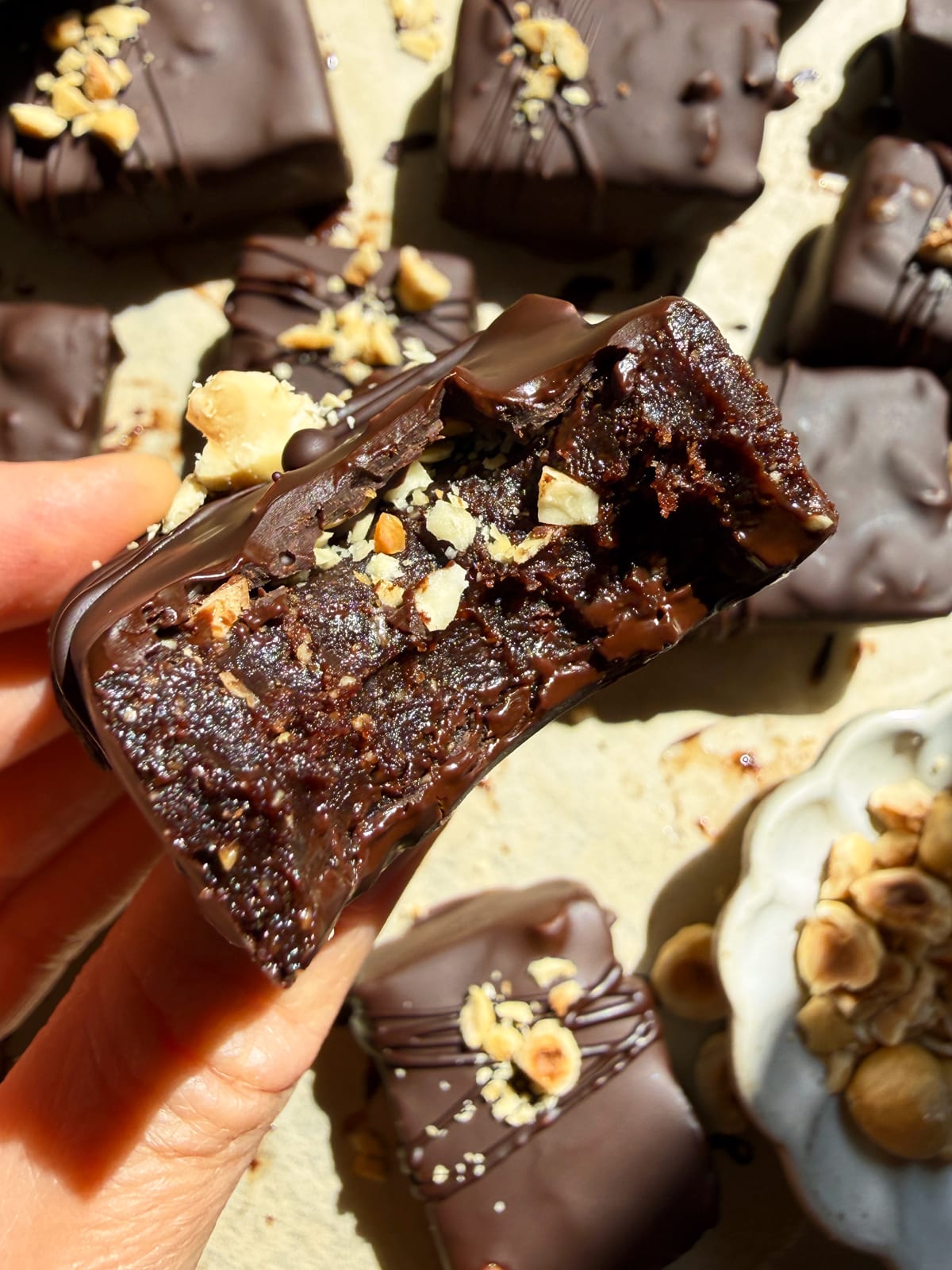 Holding a bar with a bite out of it.