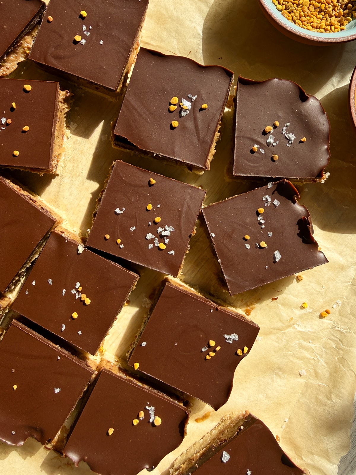 Top down view of bars that have been cut and topped with flaked salt and bee pollen.