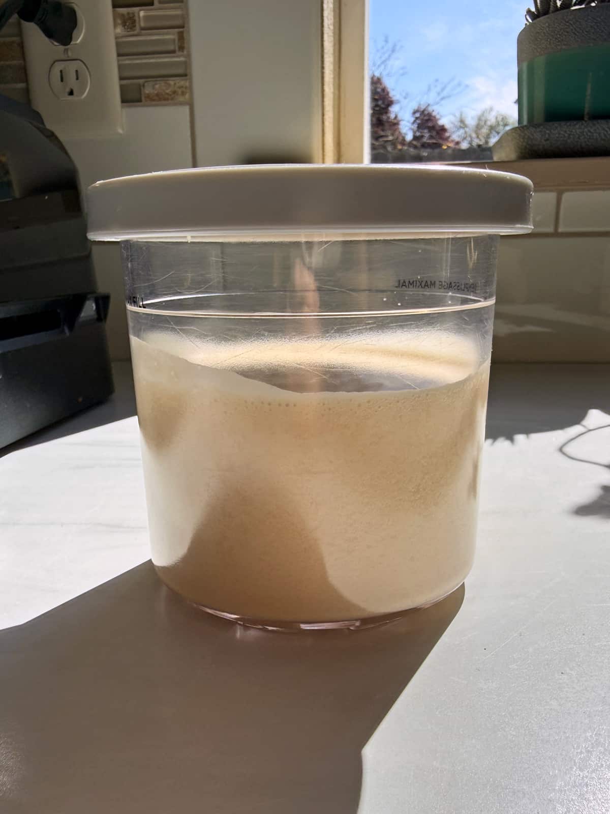 Blended ice cream ingredients in Ninja Creami pint.