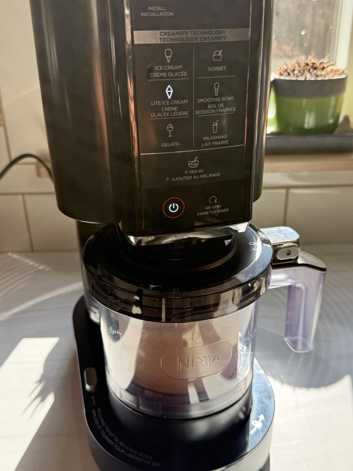Blending the ice cream in the Ninja Creami machine.