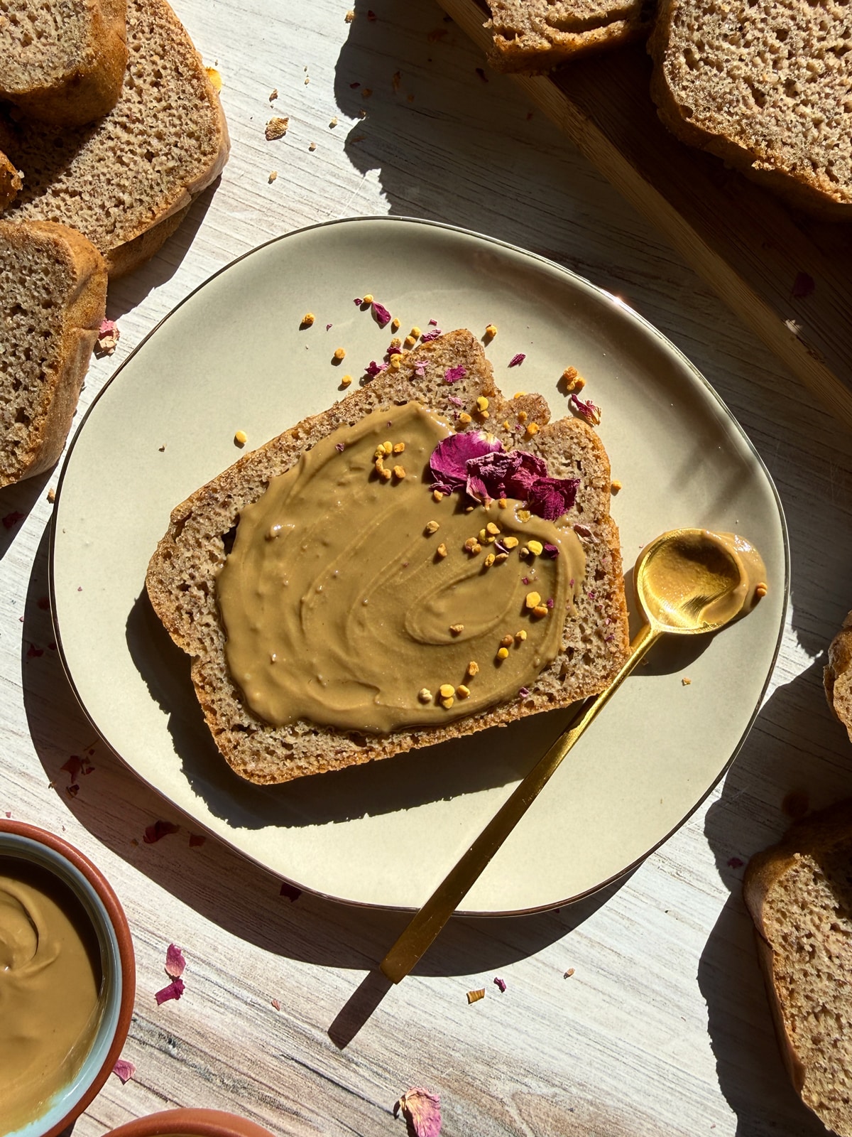 Slice of paleo bread topped with sunbutter, bee pollen and edible flowers.