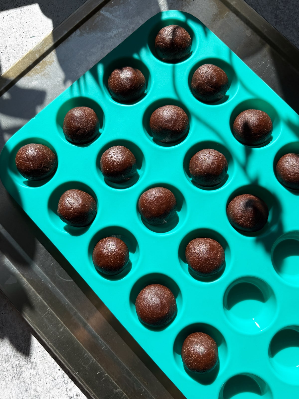 Dough rolled into balls and placed in a mini muffin pan.