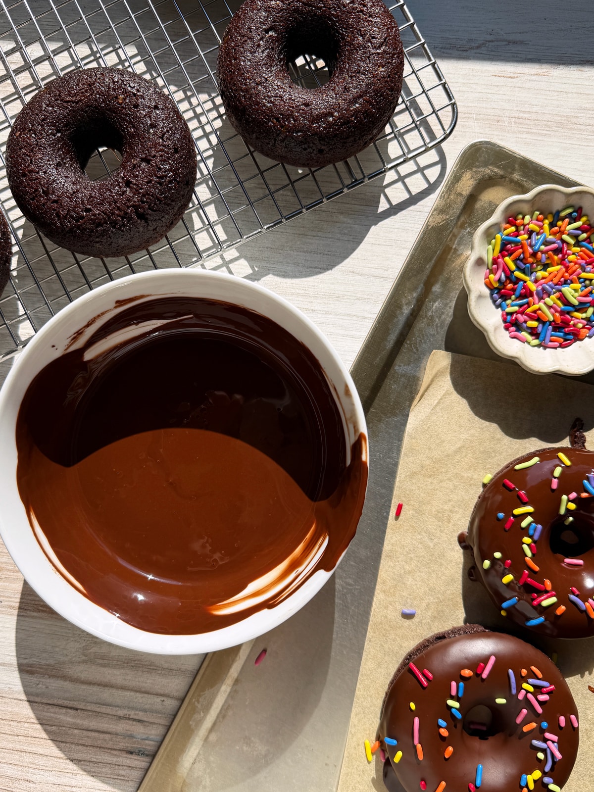 Dipping the baked and cooled donuts in the chocolate glaze.