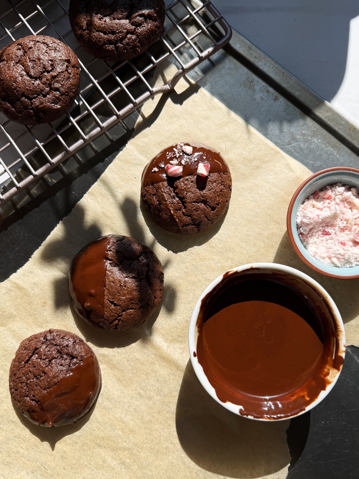 Dipping the cookies in chocolate and topping with crushed candy canes.