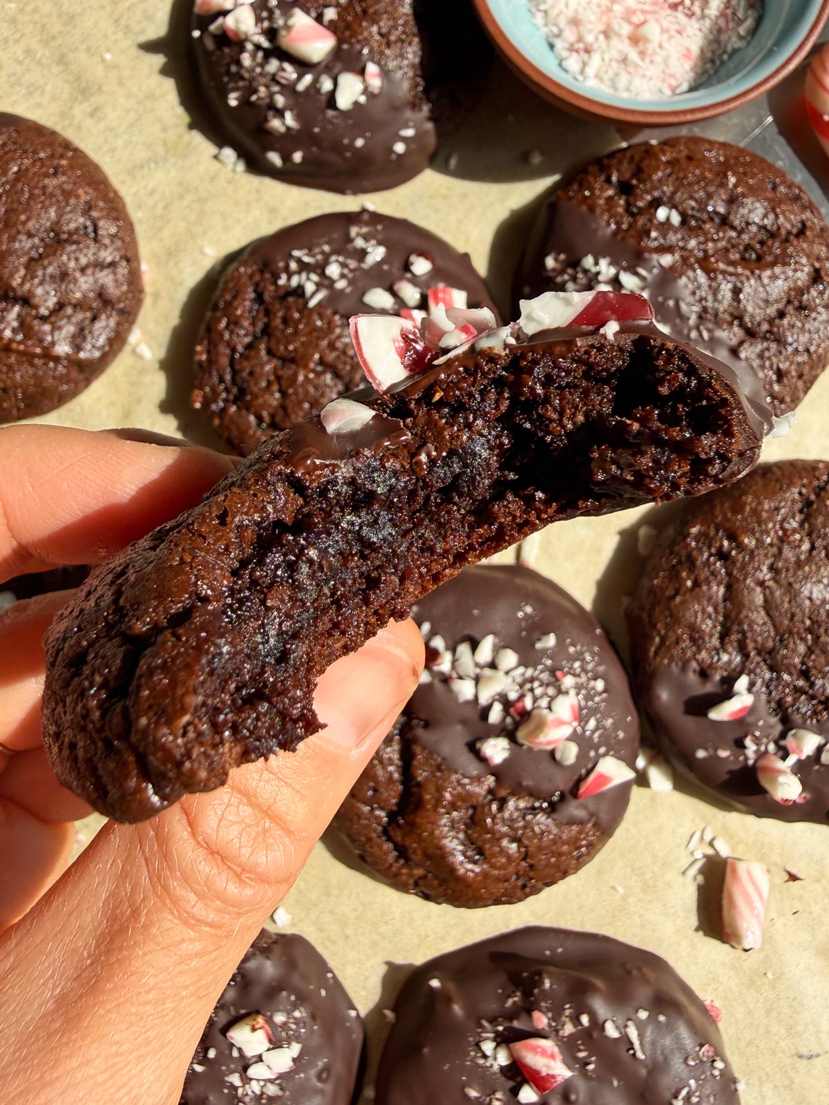 Holding a cookie with a bite out of it.