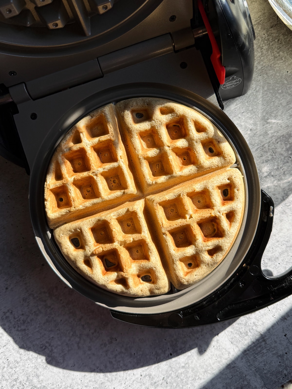 Cooking the waffle on a waffle iron.