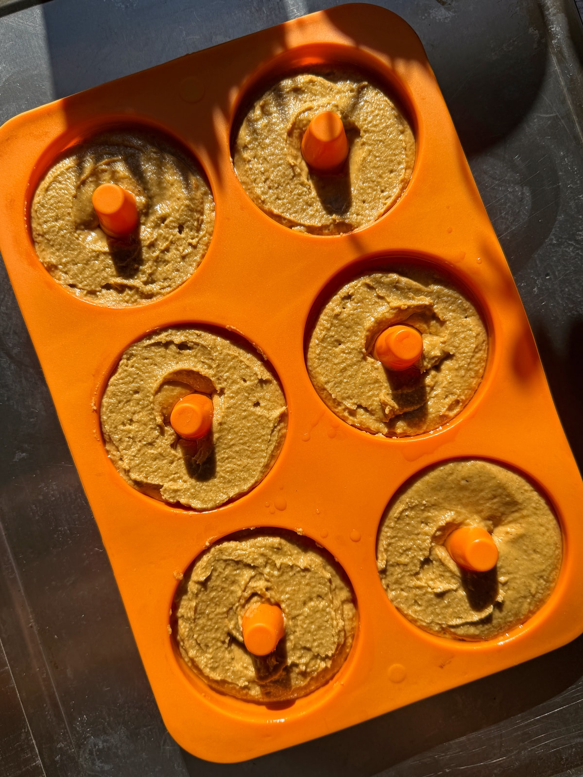 Unbaked donuts in silicone donut pan.