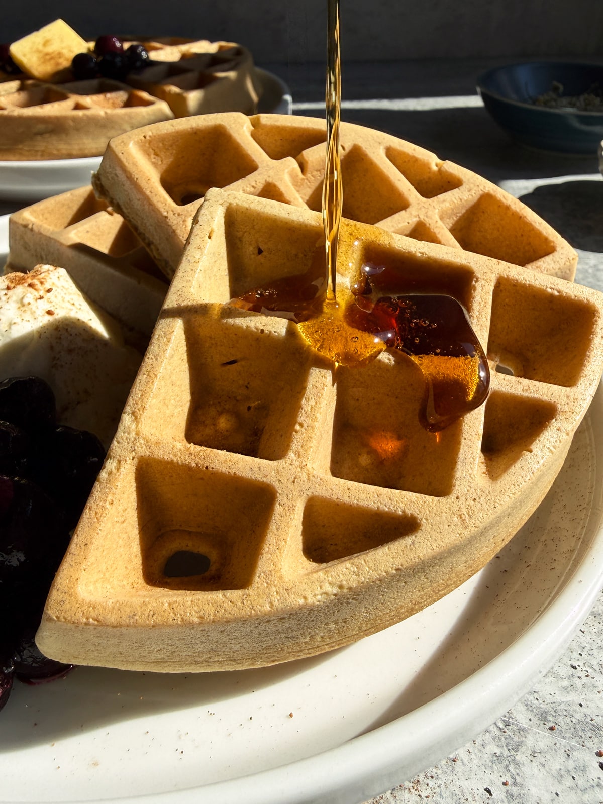 Drizzling maple syrup over the waffles.