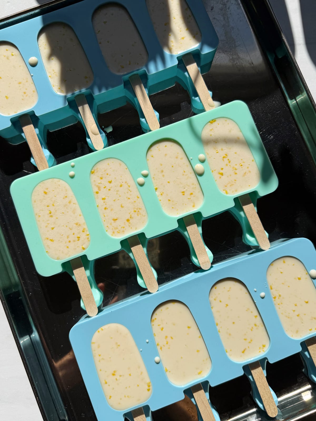 Liquid ice cream in popsicle molds, ready to freeze.
