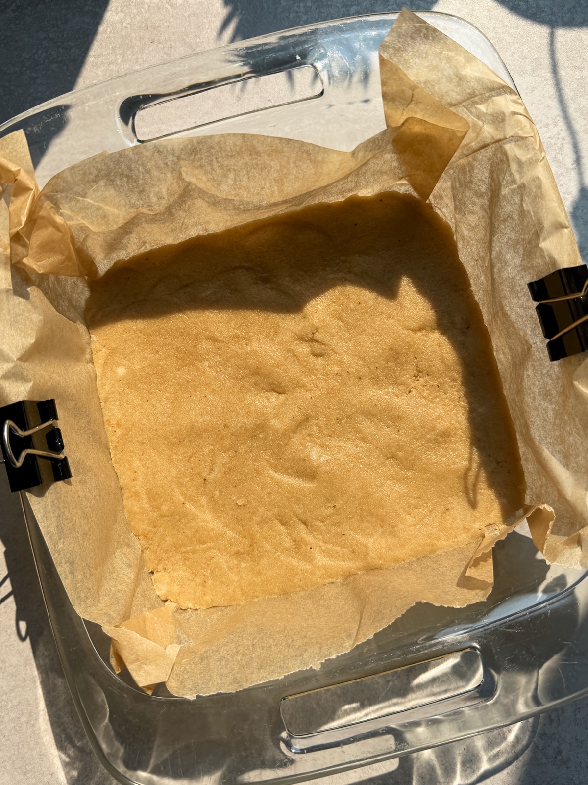 Almond flour crust pressed into the lined 8x8 inch pan.