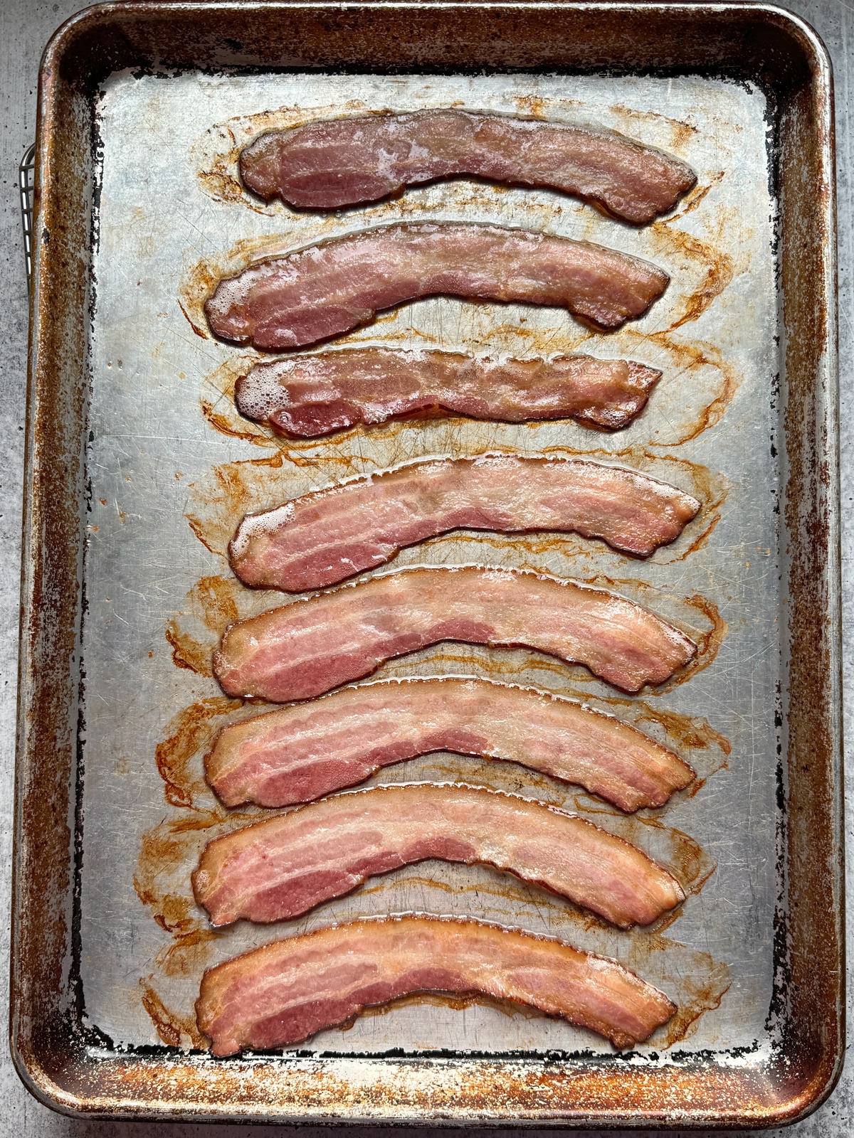 Bacon on a baking sheet after baking in the oven for 10 minutes.