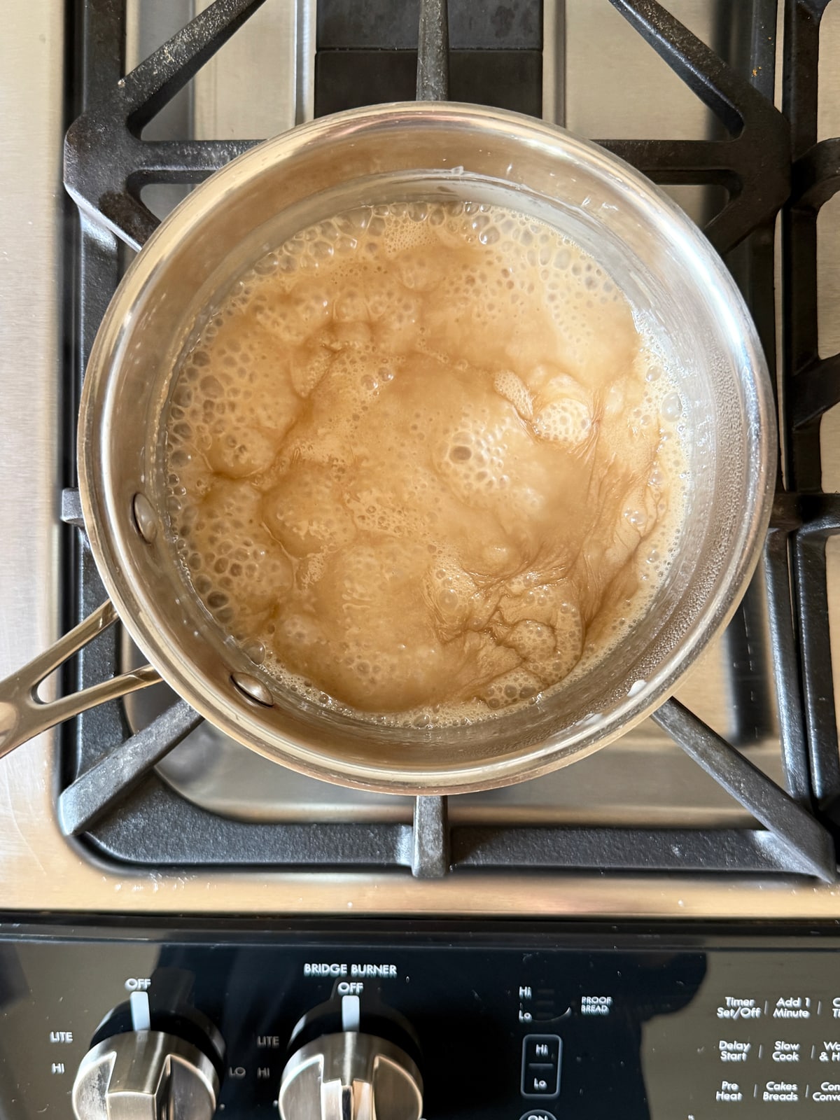 Cooking the homemade caramel over the stovetop in a small saucepan.