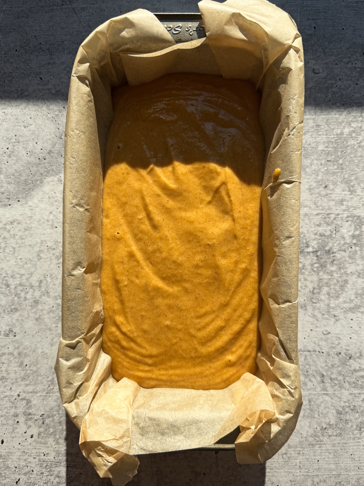 Batter in lined loaf pan, ready to bake.