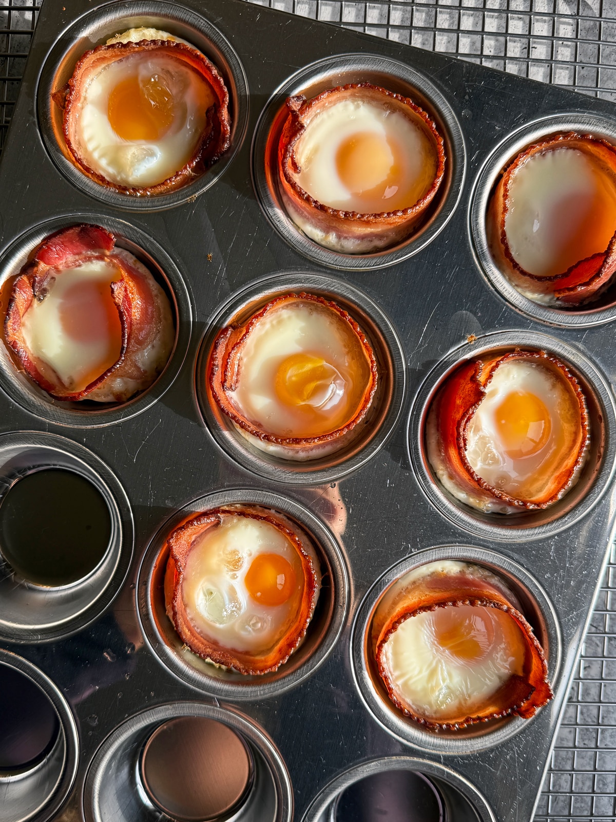 Freshly baked bacon and egg cups in muffin tin.