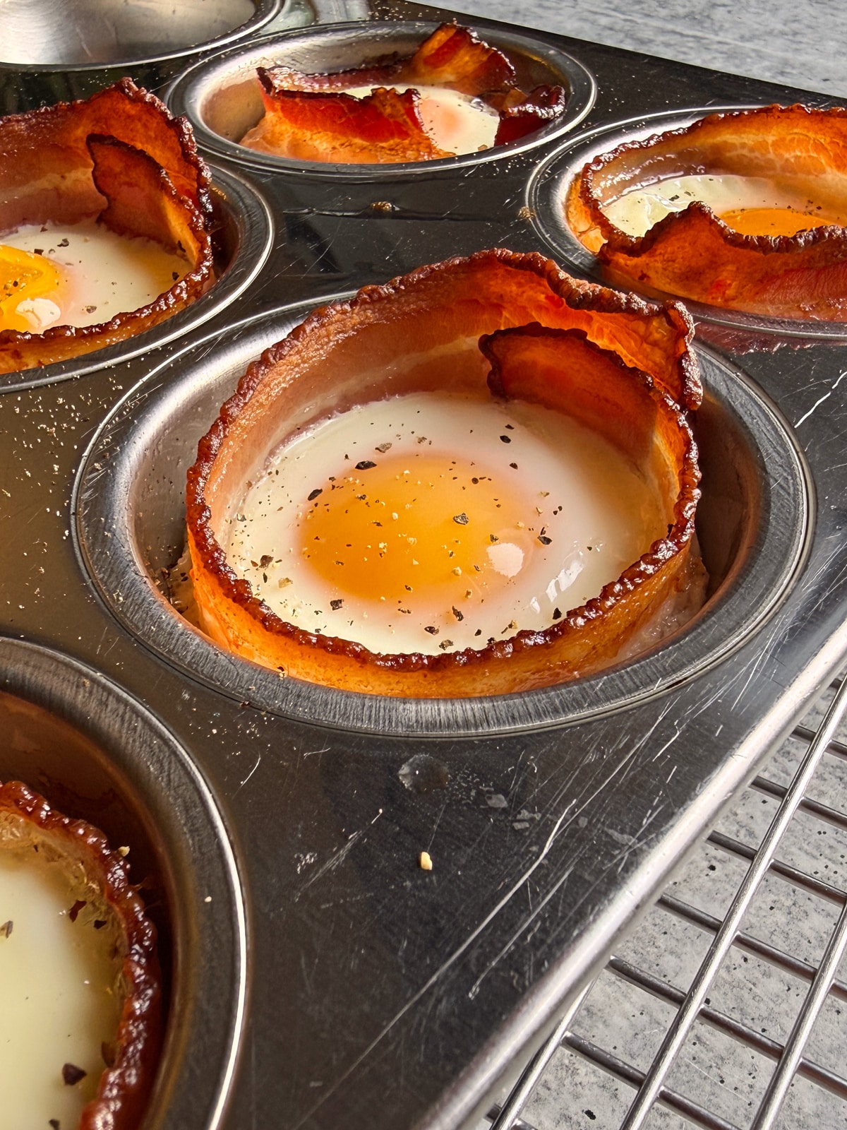 Side view of bacon and eggs cooked in a muffin tin.