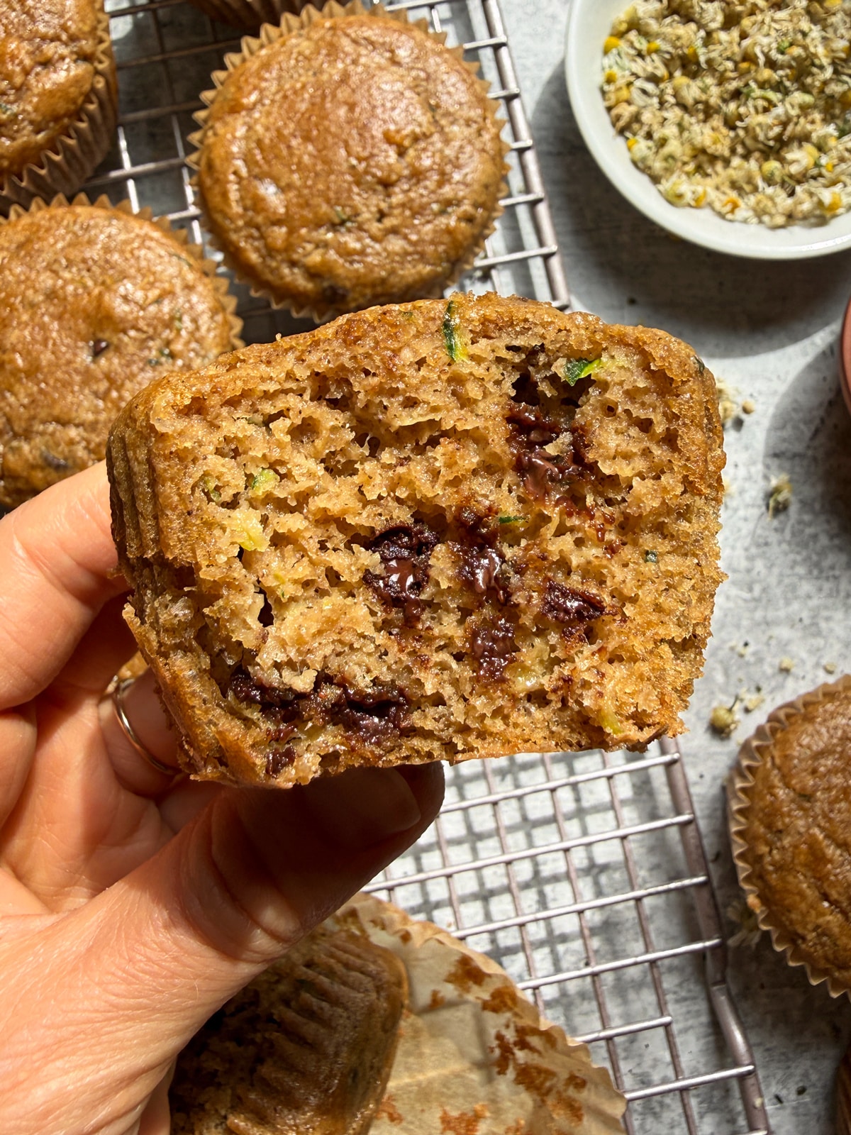 Holding a muffin with a bite out of it to show the inside texture.