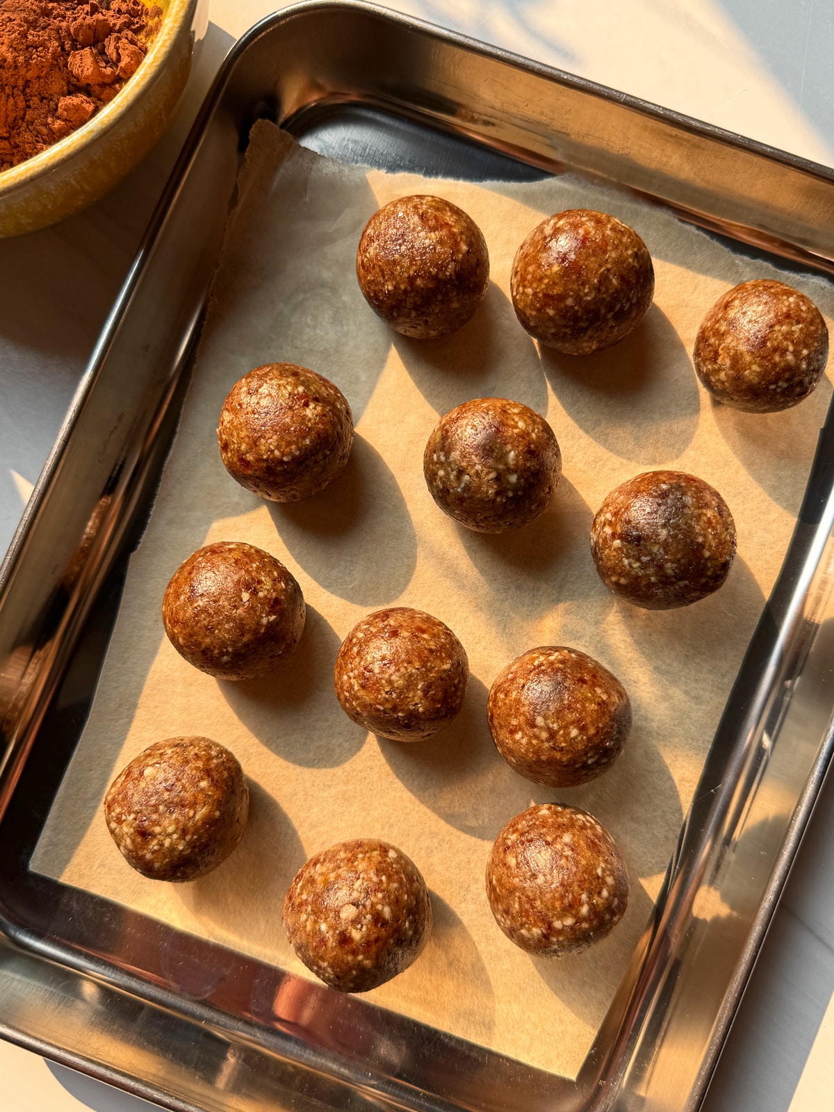 Rolled balls on lined baking sheet.