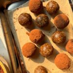 Rolling the energy bites in cocoa powder.